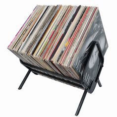 a stack of records sitting on top of a metal stand with legs and magazine holders