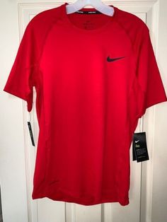 Nike Short Sleeve Activewear, Red Nike Running Activewear, Red Nike Activewear For Running, Red Athleisure T-shirt For Sports Season, Nike Go-dry Short Sleeve Activewear, Nike Dri-fit Short Sleeve Tops, University Red Moisture-wicking Tops For Sports Events, Nike Short Sleeve Training Tops, Nike University Red Tops For Sports Season