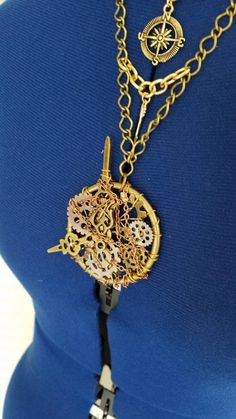 The Steampunk pocket watch pendant is hand made and one of a kind. It contains a 2 in brass ring, metal gears, clock hands, gold and silver wire and small link copper chain. It hangs on a necklace made from four different types and colors of chain to create that steampunk feel. It also features 14 karat gold plated compass rose, north star and arrow charms. Closes with a bronze lobster claw clasp. Please include your neck measurement in the comments at checkout so I can adjust it to fit. Handmade Steampunk Gold Jewelry, Steampunk Gold Jewelry With Adjustable Chain, Gold Steampunk Jewelry With Adjustable Chain, Gold Steampunk Round Pendant Jewelry, Gold Steampunk Jewelry With Round Pendant, Handmade Steampunk Brass Necklaces, Handmade Steampunk Brass Necklace, Steampunk Gold Brass Necklace, Gold Steampunk Brass Necklace