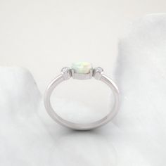 Timeless diamond and opal ring by jewelry designer Ascheron. Excellent handcrafted dainty diamond ring. Beautiful mix of brilliant cut round diamonds and smooth pear cut opal gemstone. Diamonds - 2 diamonds. Total carat weight of 0.08ct. Excellent GVS quality white diamonds. Ethically sourced. Gemstone - Real Opal, oval shape measuring 6 x 4 mm. Band - Measures 1.8 mm wide and 1.6 mm deep. Metals - Available in 14K / 18K, white, yellow or rose gold. Also in Platinum. Shipping - Free shipping to Diamond White Opal Ring For Anniversary, Diamond White Opal Ring For Promise, Anniversary Opal Ring In Diamond White With Round Cut, Opal Diamond Ring Fine Jewelry, Opal Ring With Diamond Center Stone, Diamond Opal Ring Birthstone Fine Jewelry, Diamond White Opal Ring With Accent Stones For Anniversary, Opal Promise Ring With Diamond Accents, Opal Round Cut Rings For Anniversary