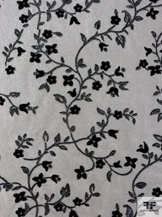 black and white floral embroidered fabric with flowers on the side, in an elegant pattern