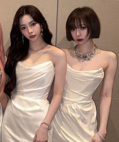 three women in white dresses standing next to each other