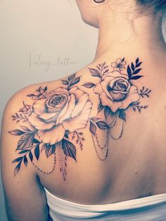 the back of a woman's neck with roses on it