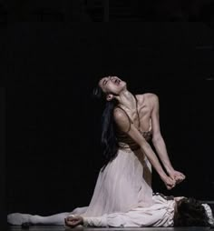 a woman in white dress laying on the ground with her legs spread out and head down