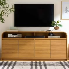 a flat screen tv mounted to the side of a wooden cabinet in a living room