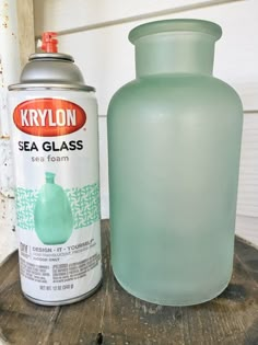 a can of krylon sea glass next to a green vase on a wooden table