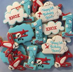 decorated cookies are arranged in the shape of airplanes and clouds with words that read knox