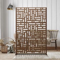 a room divider made out of wood in front of a white wall and chair