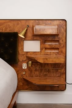 a bed with a wooden headboard and shelves on the wall next to it's night stand