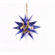 a blue and gold star ornament hanging from a chain on a white background