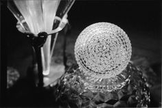 a glass ball sitting on top of a table next to a vase