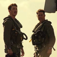 two men standing next to each other in front of an airplane