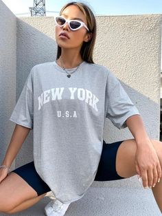 Elevate your summer wardrobe with our Retro NYC Letter Print T-Shirt. Made with breathable and durable cotton broadcloth, its classic O-neck collar and short sleeves offer both comfort and style. The retro-inspired print adds a nostalgic touch, perfect for those who appreciate vintage aesthetics. Effortlessly achieve a casual urban look while strolling through the city or hanging out with friends. Designed by Thekittenpark Summer Leisure Short Sleeve Tops, Short Sleeve Tops For Summer Leisure, Summer College T-shirt With Screen Print, Short Sleeve T-shirt For Summer Leisure, Summer Crew Neck T-shirt For Leisure, Casual Gray T-shirt For College, Crew Neck T-shirt For Leisure In Summer, Short Sleeve T-shirt For Leisure In Summer, Summer Leisure T-shirt With Short Sleeves