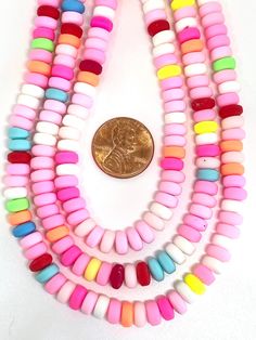 ♥ Rekindle the nostalgia of childhood with our baby pink heishi beads. Adorned with vibrant colored accents, they come together to resemble the beloved candy necklaces of yesteryears. Perfect for playful, sweet-inspired jewelry pieces. ♥ Made from polymer clay. These beads do not come strung ♥ Dimensions: 6mm. Choose the quantity you need. About 100 beads = 16 inch strand Pink Heishi Beads Bracelet With Colorful Beads, Pink Heishi Beads Necklace With Tiny Beads, Pink Heishi Beads Necklace, Pink Necklace With Colorful Heishi Beads, Playful Pink Heishi Beads Bracelet, Candy Necklace, Beads Candy, Candy Necklaces, Our Baby