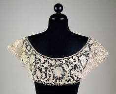 a mannequin wearing a black and white top with lacy lace on it's shoulders