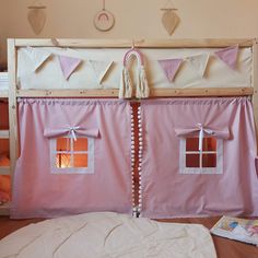 there is a pink bed with two windows on the top and one window in the bottom