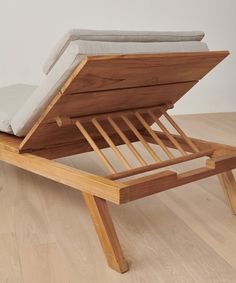 a wooden bed frame with a mattress on it's back and side rests on the floor