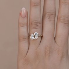 a woman's hand with an engagement ring on top of her left hand, and the other half of her right hand