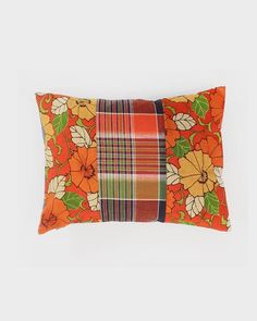 an orange and green pillow with flowers on it