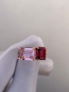 a pink tourmaline ring is being held up