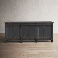 an old, black cabinet is on the floor in front of a white wall and wooden floors