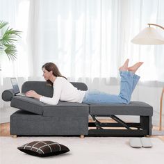 a woman is laying on the couch with her feet up and laptop in front of her