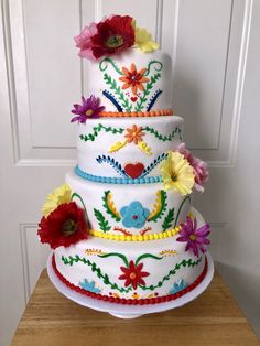 a multi layer cake decorated with flowers and beads