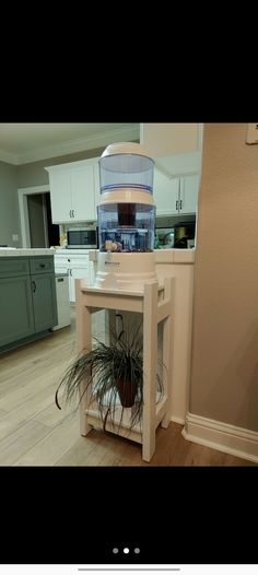 a small table with a potted plant on it in the middle of a kitchen