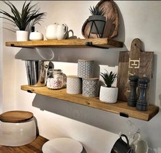 two wooden shelves filled with pots and other items on top of each shelf in a room