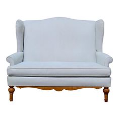 an upholstered white chair with wooden legs and arm rests against a white background