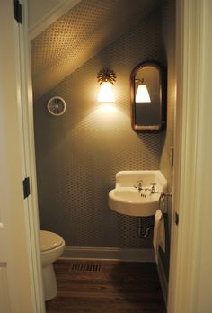 a bathroom with a sink, mirror and light on the side of the door way