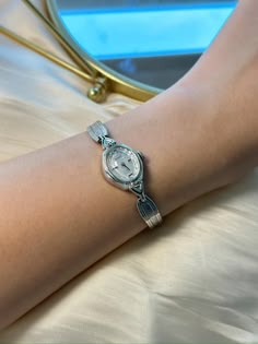 This exquisite vintage Baylor ladies watch showcases a timeless silver tone finish with a beautifully detailed textured bracelet and an elegant oval case. The intricate silver dial is adorned with delicate patterns, adding a touch of grace to this classic timepiece. Powered by a reliable mechanical movement, this watch runs and keeps time accurately. The case size is approximately 16.2mm, and it fits comfortably on a wrist size of up to 15.25cm. Please note the watch has minor cosmetic imperfect Silver Watch For Ladies, Vintage Watches Women Silver, Silver Vintage Watch, Vintage Bulova Watches, Silver Watches, Textured Bracelet, Silver Watches Women, Bulova Watches, Vintage Watches Women