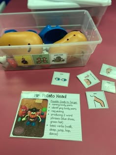 a plastic container filled with toys on top of a pink table next to other items