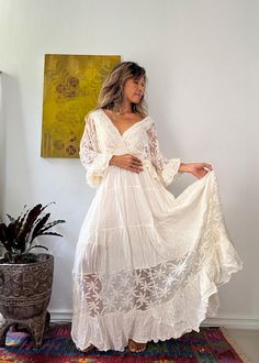 Handmade Bohemian Lace Trim Wedding Dress - Vintage-Inspired with Batwing Ruffle Sleeves and Adjustable Back Tie This flowing bohemian lace trim wedding dress is perfect for free-spirited brides or special occasions. Handmade with 100% soft cotton and delicate lace, it features romantic batwing ruffle sleeves and a flattering elastic waist. The dress is fully lined for comfort and comes with adjustable strings at the back to ensure a custom fit. The off-white beige fabric, paired with white lace Tiered Gown, Vintage Inspired Dresses, Beige Fabric, Boho Maxi, Free Spirited, Boho Maxi Dress, Ruffle Sleeves, Wedding Dresses Vintage, White Beige