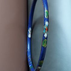 A classic bangle in cloisonne' enamel. VINTAGE 1970's collectible. Layer and stack bracelet. Rich imperial blue...a dramatic shade of indigo, with an almost purple tone. Floral accents are red, green, and gold. Nicely textured surface, and beveled edge. Complement your Autumn style, tweeds, silks, denim. Slim wrist size. 1970's. Gift boxed. VINTAGE Inner Circle: 2-1/2" Width: 3/16" Vintage Multicolor Enamel Bangle, Vintage Round Enamel Bracelets, Vintage Enamel Round Bracelets, Vintage Round Enamel Bangle, Vintage Enamel Bangle As A Gift, Vintage Enamel Bangle For Gift, Vintage Enamel Bangle As Gift, Vintage Handmade Enamel Bangle, Vintage Enamel Bangle Gift