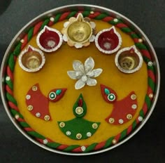 a decorative plate with buttons and decorations on the top, sitting on a black surface