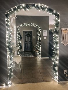 a hallway decorated for christmas with lights and decorations on the door, along with a chair