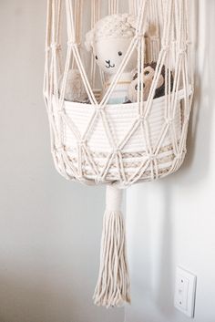 a white hammock hanging from the ceiling with two stuffed animals in it,