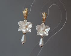 Handmade earrings with ivory pearl orchids, pearl tear drops and gold colour findings. (crystal hooks or hoops) Bases for charm are made from zinc allow nickel free (silver plated) Material of flowers- polymer clay with pearl cover. Polymer clay isn't afraid of water, strong, but you must take care as any jewelry piece. Gorgeous gift for women and girls as handmade item. Sizes: Length of double orchid earrings-  2.3 inches / 60 mm Length of single orchid earrings-  1.7 inches / 45 mm ALL DANGLE EARRINGS- - https://www.etsy.com/shop/BuduartJewelry?ref=simple-shop-header-name&listing_id=1081157445§ion_id=34098196 If you like this item you can visit my shop: https://www.etsy.com/shop/BuduartJewelry My first shop(jewelry, accessories, home decor): https://www.etsy.com/shop/BuduartJulia Thanks Clay Earrings Flower, Orchid Jewelry, Orchid Earrings, Tear Drops, Earrings Flower, Ivory Pearl, Gold Colour, Earrings Wedding, Gorgeous Gift