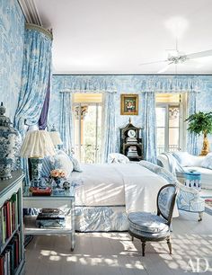 a bedroom with blue and white wallpaper and furniture