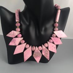 "This is a lovely vintage necklace featuring diamond-, sphere-, and cuboid-shaped beads made of a beautiful pink gemstone. On the Presidium gem tester, it reads in the tourmaline, garnet, iolite range (see listing video). It is most likely rhodonite. The necklace has a barrel clasp. Weight: 112 grams (3.95oz.) Length: 18\" (45.72 cm) Very good condition with no visible imperfections. All jewelry is sold in used, preowned condition. Vintage and antique items are expected to have some wear, imperf Vintage Natural Stone Beaded Necklaces, Vintage Gemstone Beads For Gifts, Vintage Beaded Pendant Necklace With Natural Stones, Vintage Pendant Beaded Necklace With Natural Stones, Pink Spiritual Necklace With Faceted Beads, Vintage Long Gemstone Bead Necklace, Vintage Long Beaded Necklace With Gemstone Beads, Vintage Long Gemstone Beaded Necklace, Pink Polished Beads Spiritual Jewelry