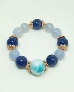 Unique high Quality 18.2mm Larimar with 14.2mm Tanzanite and 13.8mm mix 13mm Blue Chalcedony crystal bracelet. A high quality Larimar leads this bracelet with a superb calming and intelligent energy followed by natural Tanzanite and Chalcedony to harmonize the energies. This is One of a Kind crystal bracelet that combines & harmonises the exquisite healing powress of Larimar, Tanzanite & Chalcedony. Ideal for healers, good career EQ and past life awareness for better future. Larimar is h Blue Aquamarine Natural Stone Bracelets, Blue Aquamarine Bracelets With Natural Stones, Blue Gemstone Bracelets With Round Beads, Blue Moonstone Bracelets For Healing, Blue Moonstone Bracelet For Healing, Spiritual Blue Moonstone Bracelets, Blue Aquamarine Gemstone Bracelets, Blue Moonstone Beaded Bracelets With Gemstone Beads, Blue Round Crystal Bracelet For Healing