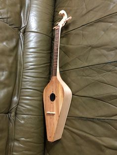 a wooden instrument sitting on top of a green couch