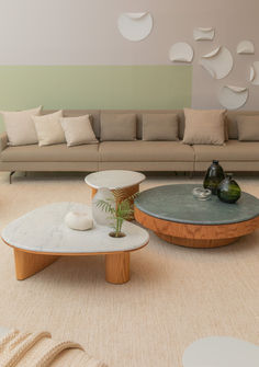 a living room with couches, tables and vases on the floor next to each other