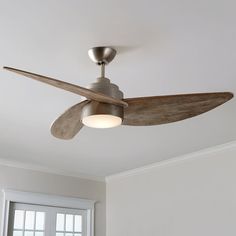 a ceiling fan in a room with white walls and wood trim around the light fixture