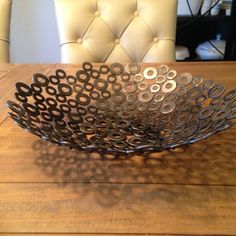 a metal bowl sitting on top of a wooden table