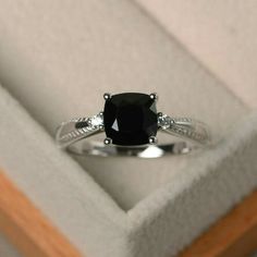 a black diamond ring sitting in a box