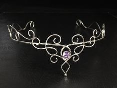 I have fabricated a sterling silver wedding circlet, or bridal tiara, which is designed to be worn for a wedding, a Renaissance event, or perhaps a hand-fasting ceremony. A beautifully handmade circlet with an elegant, Princess feel, yet still elegant to be worn and enjoyed for any high end function! This piece will go around behind the ears and is tied off, in the back, by an elastic jeweler's cord so that it will remain snug and in place while in motion. This works better than using a chain li Handmade Adjustable Crown Headband, Handmade Adjustable Crown, Bohemian Round Crown Headpiece For Wedding, Adjustable Structured Crown Headpiece As Gift, Bohemian Wedding Headpiece With Round Crown, Elegant Ceremonial Crown Headpieces, Silver Headband Crown For Wedding, Wedding Jewelry With Crown Design, Elegant Ceremonial Headpiece With Pinched Crown