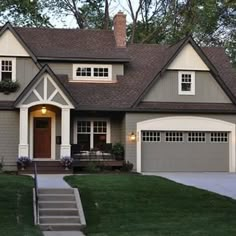 a gray house with white trim and brown roof