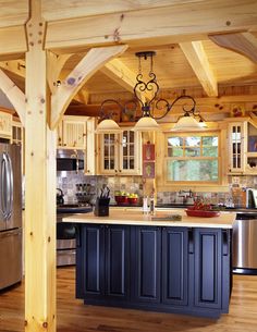 a kitchen with an island in the middle of it and lots of wood flooring